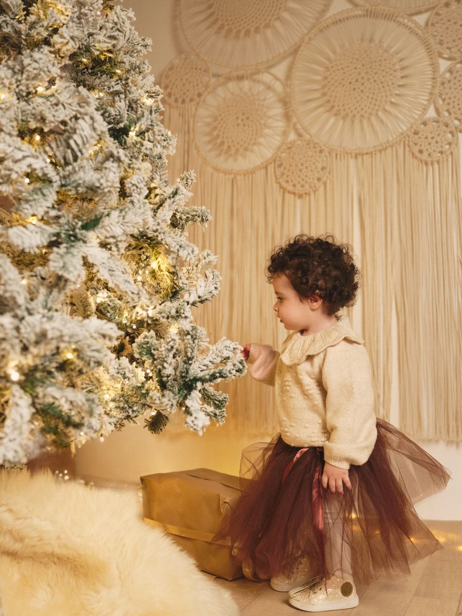 Mini sessione di Natale in studio a Siracusa: bambina con la gonna di tulle accanto all'albero