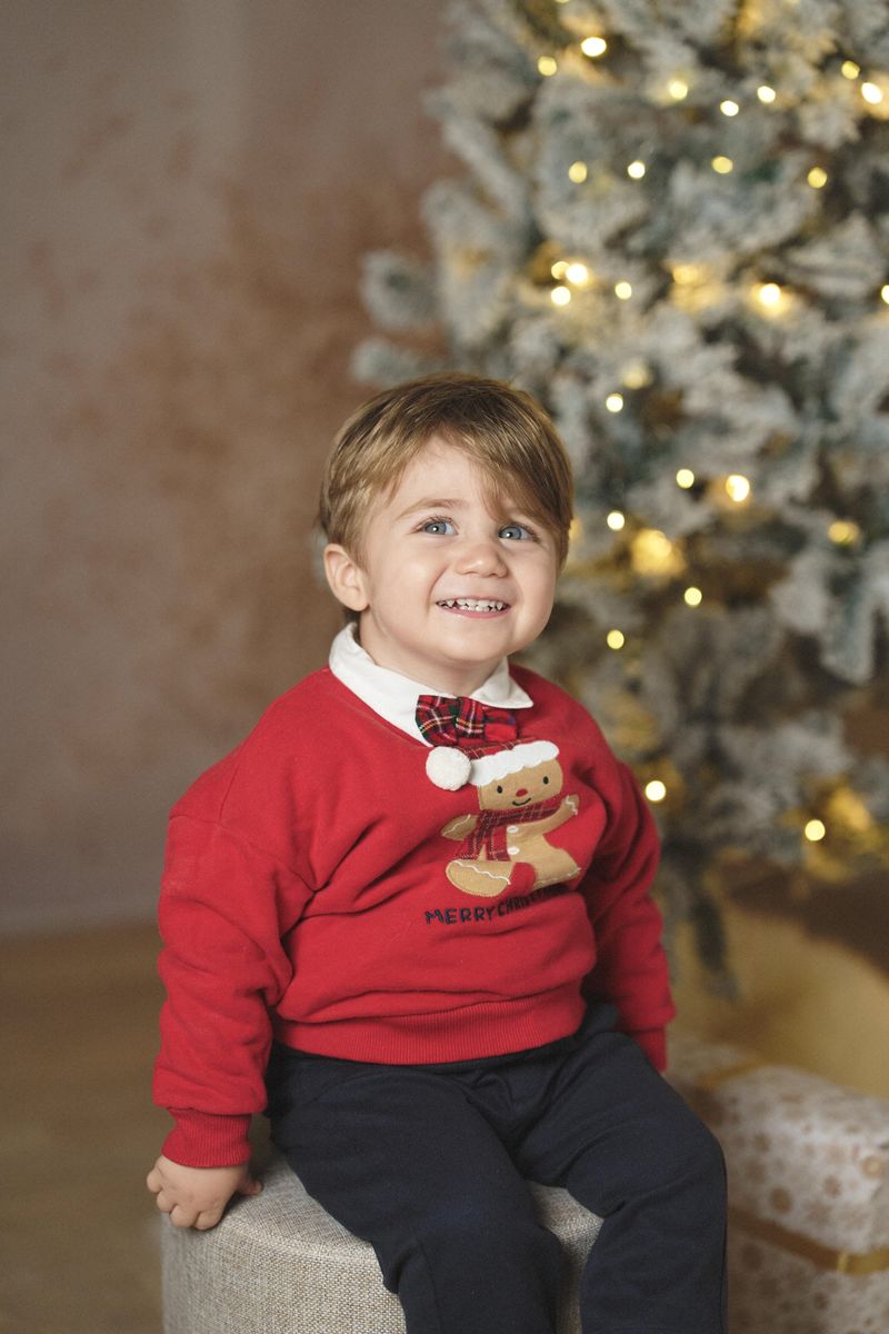 Mini sessione di Natale in studio a Siracusa: bambino con il maglione rosso di Natale