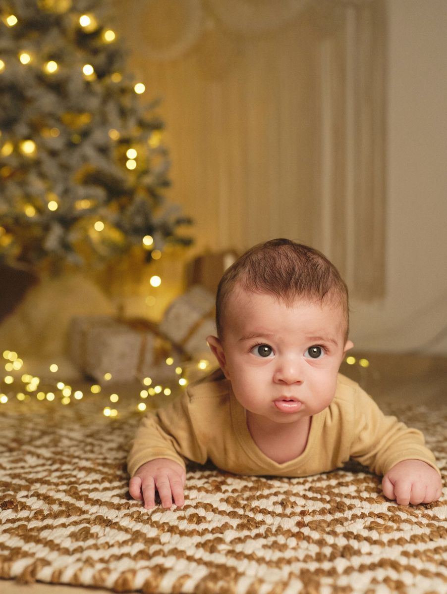 Mini sessione di Natale in studio a Siracusa: neonato a pancia in giù tra le luci di Natale