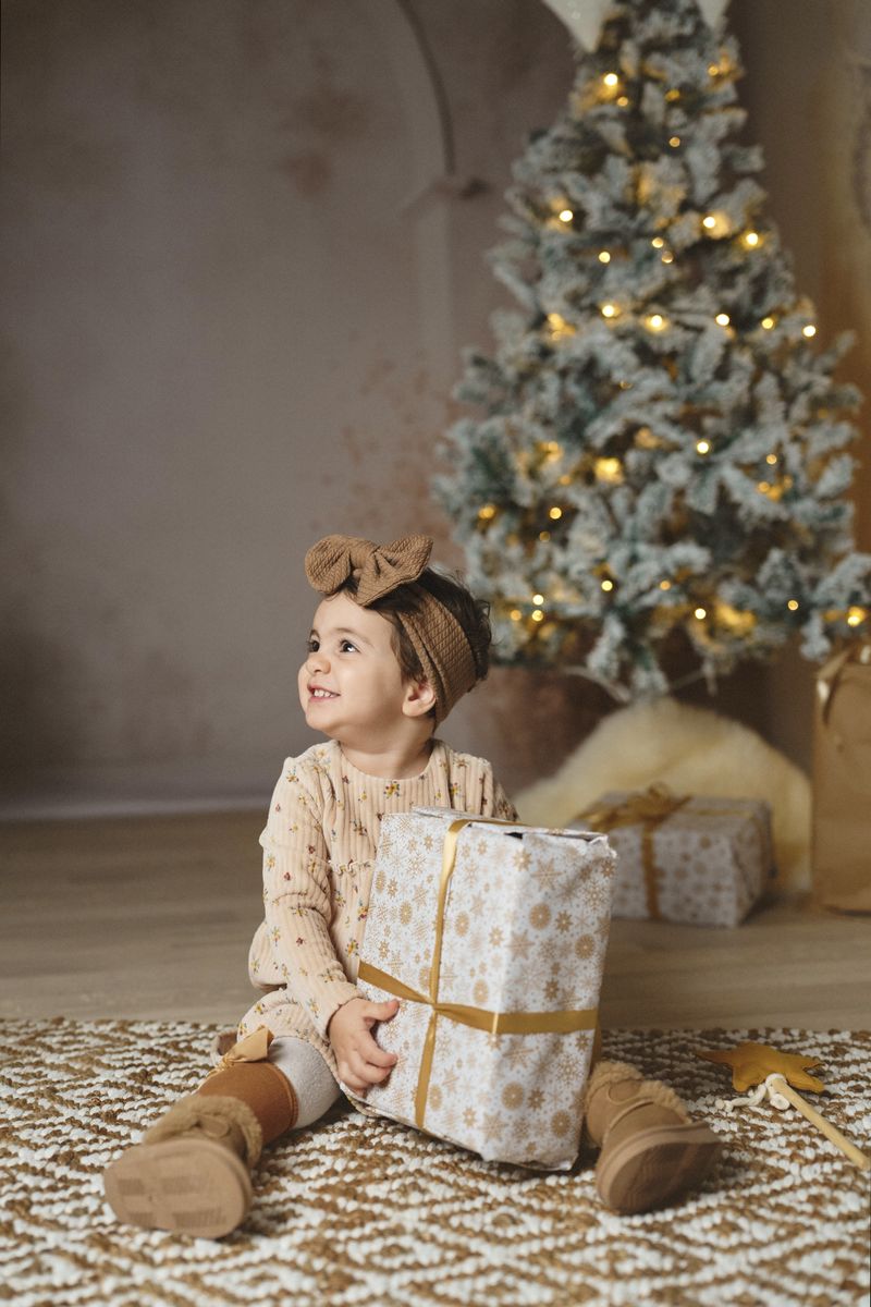 Mini sessione di Natale in studio a Siracusa: bambina con il regalo in mano