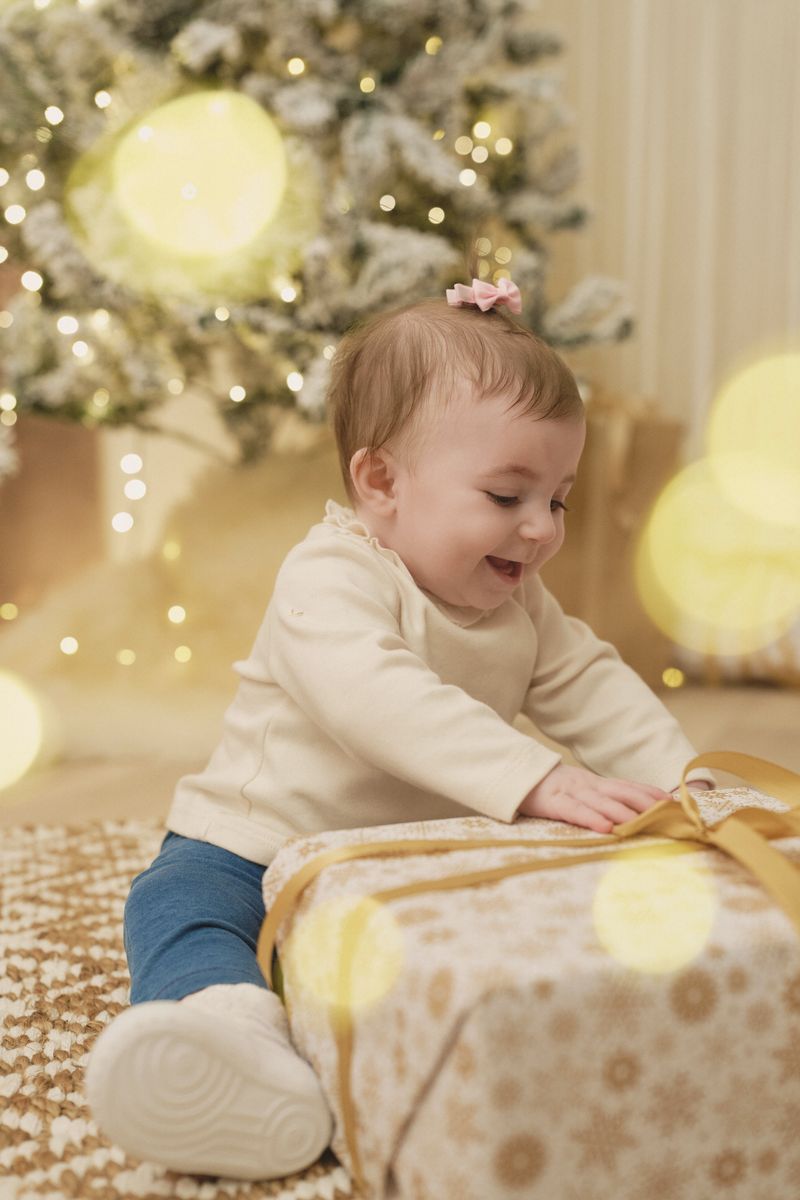 Mini sessione di Natale in studio a Siracusa: bimba che apre un regalo tra le luci
