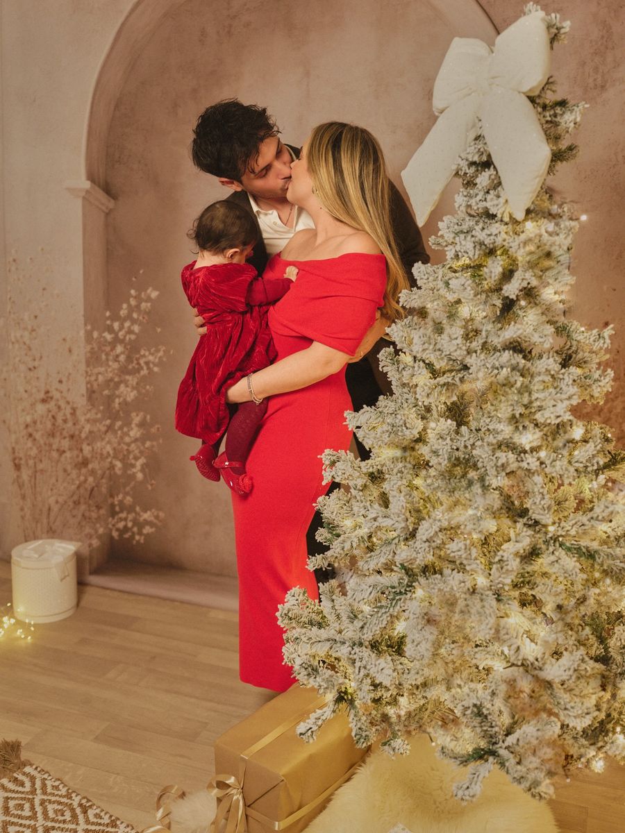 Mini sessione di Natale in studio a Siracusa: coppia abbracciata con la bambina in braccio
