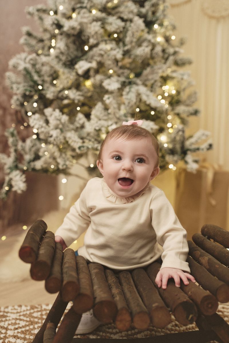 Mini sessione di Natale in studio a Siracusa: bimba seduta alla panchina di legno