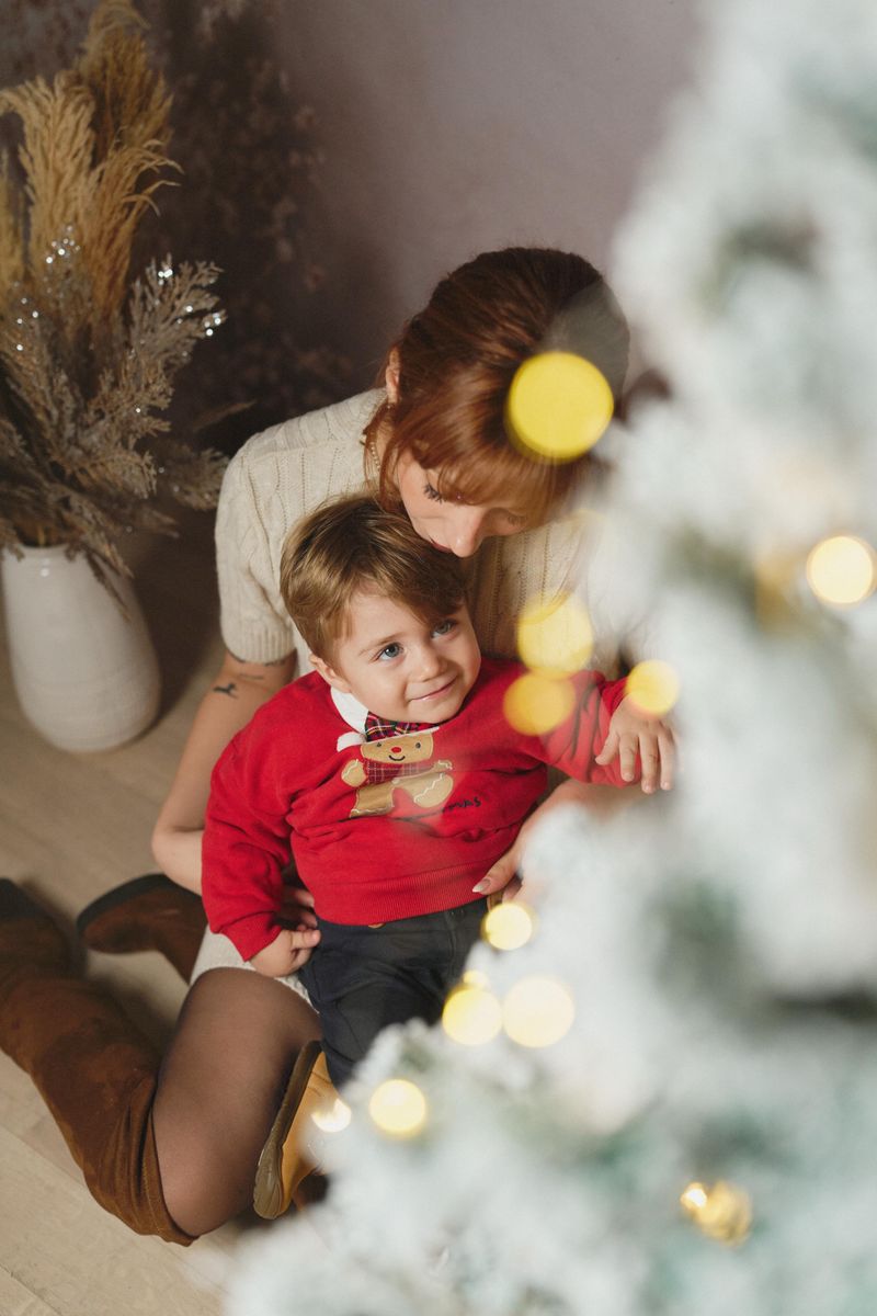 Mini sessione di Natale in studio a Siracusa: mamma e bambino dietro l'albero innevato