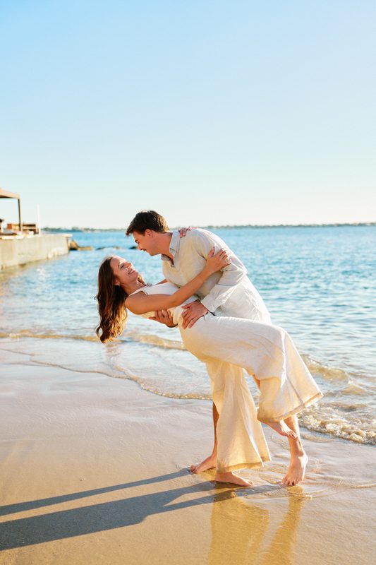 He dips her for a kiss on a little beach in Ortigia