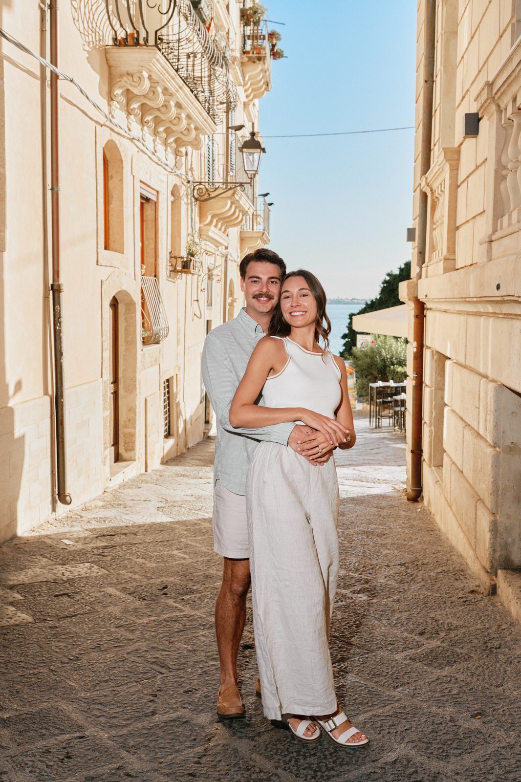 Couple hugging in a sunny street of Ortigia, Syracuse