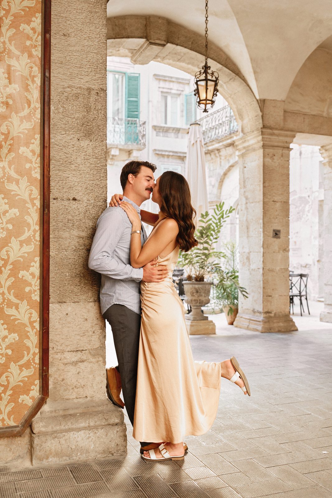 Couple kissing under an arcade in Ortigia, Syracuse