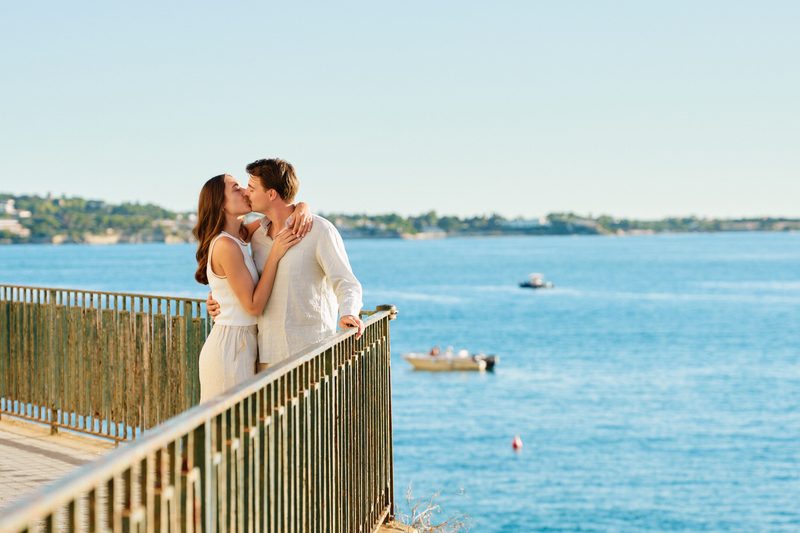 A couple kissing by the railing of Lungomare Alfeo, Syracuse