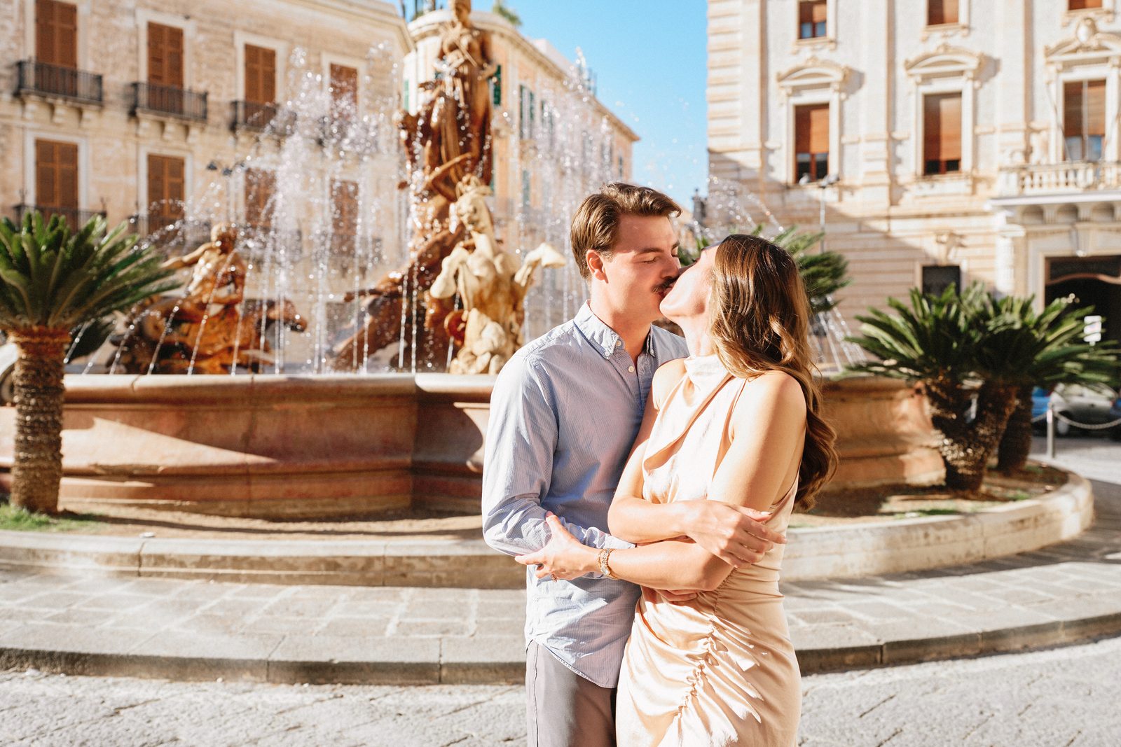 Couple kissing by the Fountain of Diana in Piazza Archimede, Ortigia