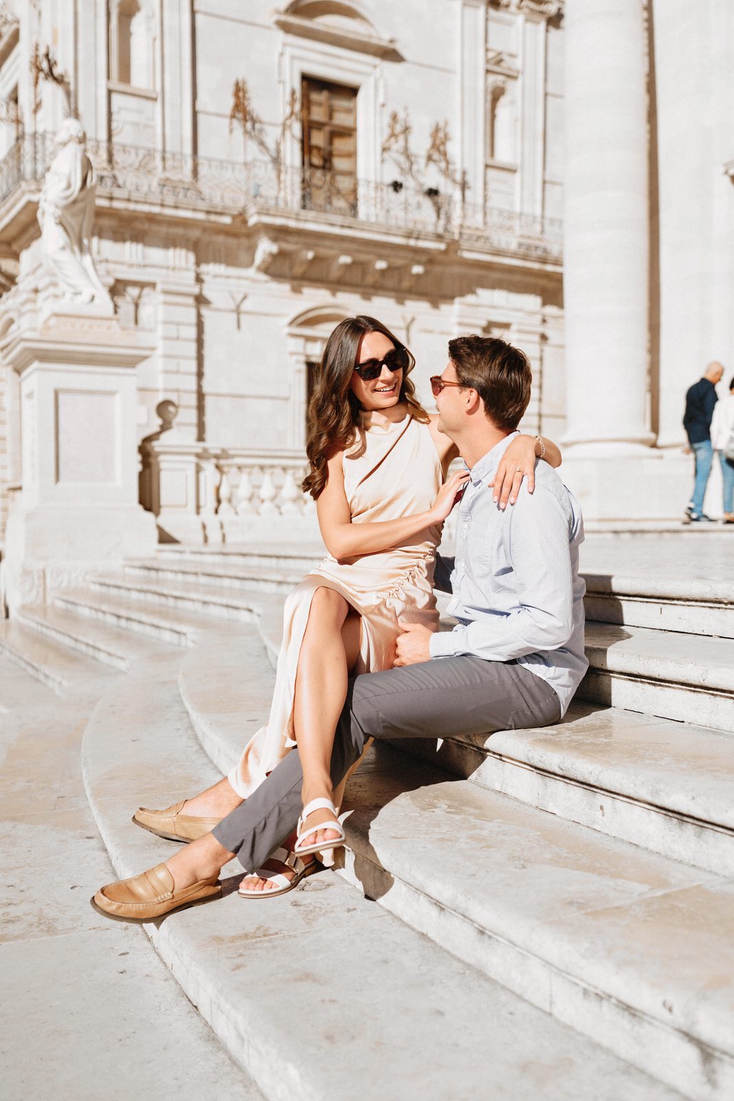 Couple laughing on the steps in Piazza Duomo, Syracuse