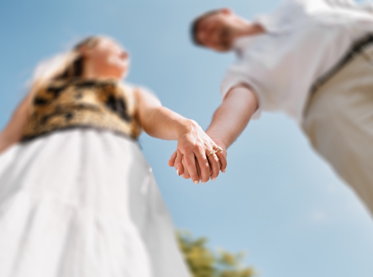 Holding hands against the blue Sicilian sky, seen from below
